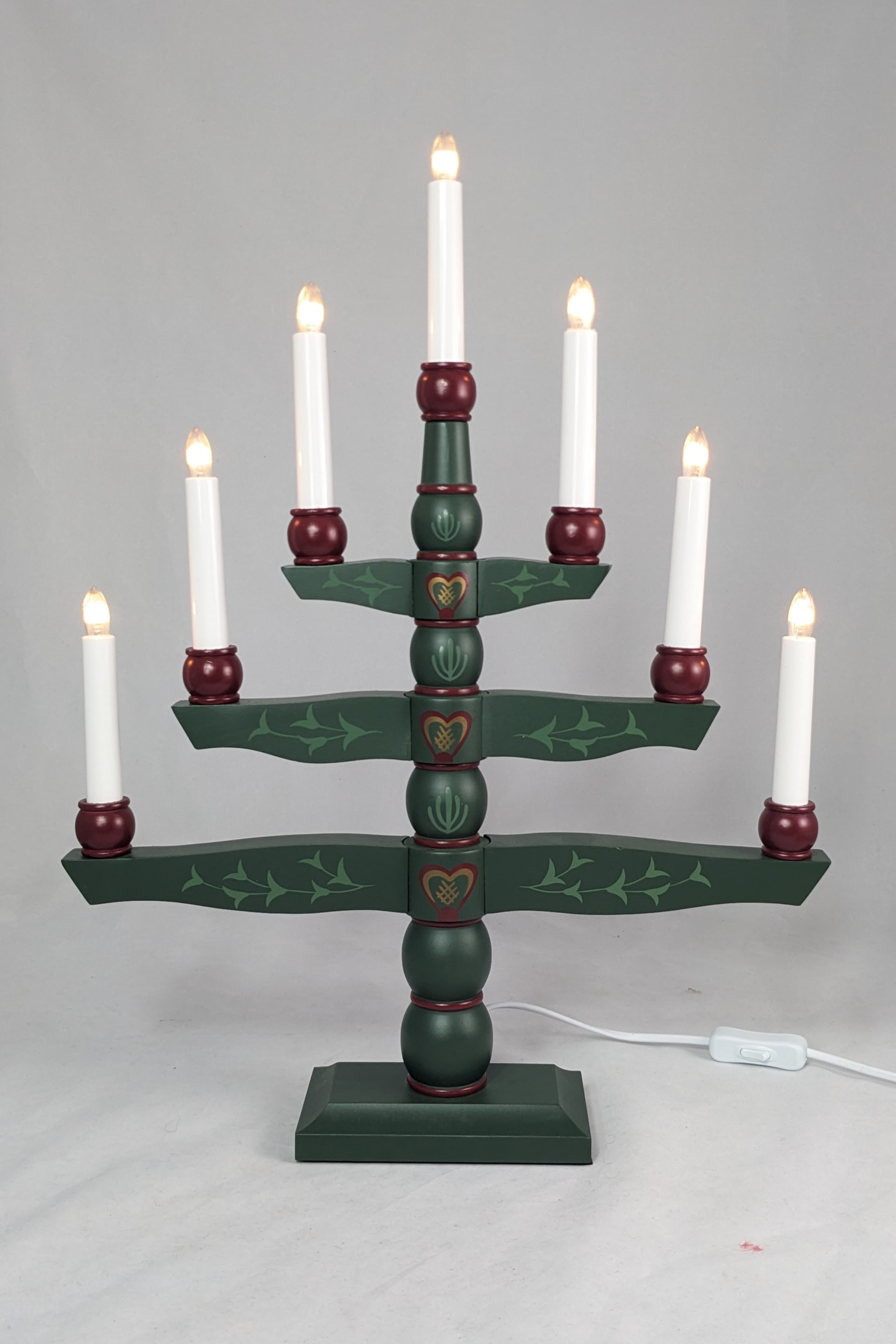 Green candelabra with 7 lights, on 3 branches and one light on each side. Each branch gets smaller as it reaches the top, resembling a tree. 