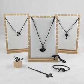 A collection of the forged jewelry, with the snake bottle opener propped up on one of the necklace displays. 