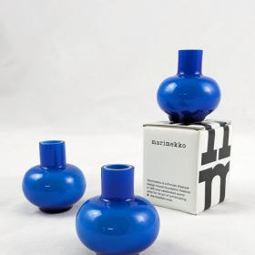 three royal blue glass vases, one is atop of of the white and black packaging
