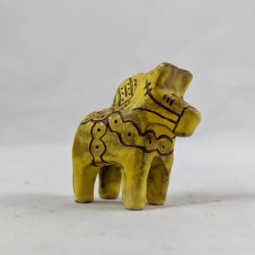 Yellow ceramic dala horse facing to the right. 